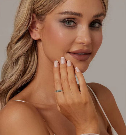 Woman with a ring on her finger against a neutral background