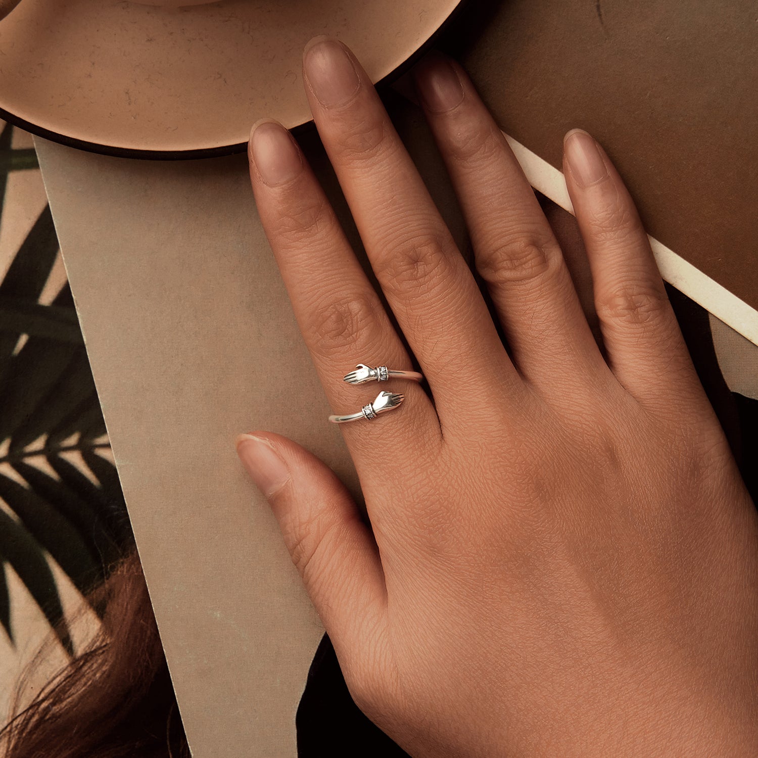 hug ring with embracing hands silver finish